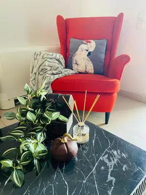 a living room with a red chair and a plant at New Modern 2BD aprt with shared rooftop pool B2 in Athens