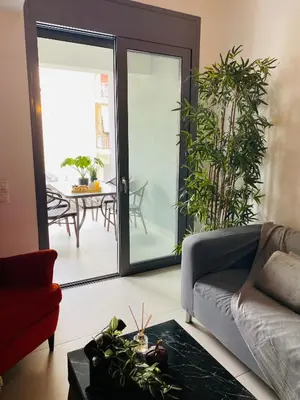 a living room with a couch and a table at New Modern 2BD aprt with shared rooftop pool B2 in Athens