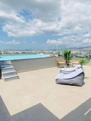 a patio with a swimming pool and aitating at New Modern 2BD aprt with shared rooftop pool B2 in Athens