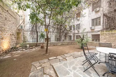 a patio with a table and chairs next to a building at Zen Orchid, Kolonaki in Athens