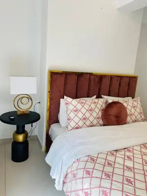 a bedroom with a bed with a wooden headboard and a table at NEW 2BD Aprt with Shared Rooftop Pool B3 in Athens