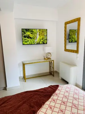 a bedroom with a bed and a table and a mirror at NEW 2BD Aprt with Shared Rooftop Pool B3 in Athens