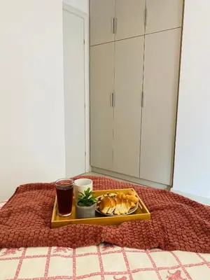a tray of food and a drink on a bed at NEW 2BD Aprt with Shared Rooftop Pool B3 in Athens