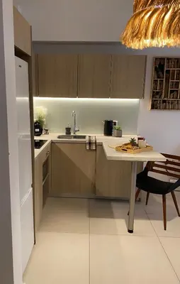 a kitchen with wooden cabinets and a table and a refrigerator at NEW 2BD Aprt with Shared Rooftop Pool B3 in Athens