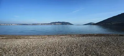 a large body of water with mountains in the background at Luxury 2bdr apartment with sea view and 50m from the beach in Porto Rafti