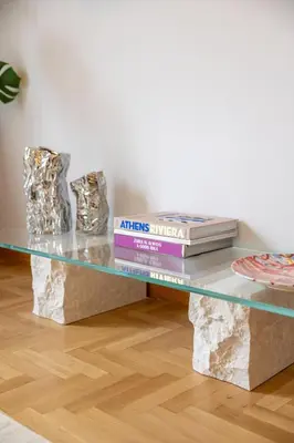 a glass table with some books on top of rocks at Ernesto Apartment in Athens