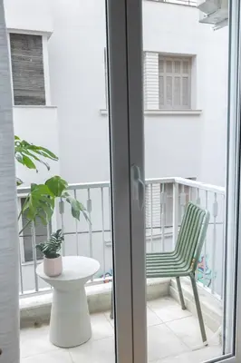 a green chair sitting on a balcony at Ernesto Apartment in Athens