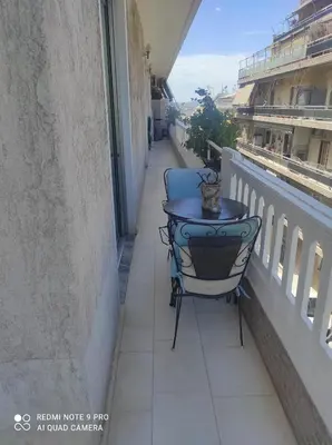 a blue chair sitting on a balcony with a table at Piece of Gold 7 minutes from Acropolis in Athens
