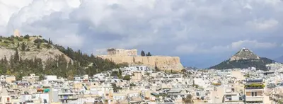 a group of white buildings on a mountain at Urban Oasis with Acropolis Views by GHH in Athens