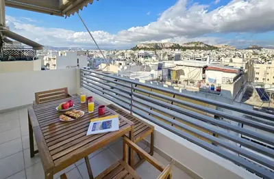 a table on a balcony with a view of a city at Urban Oasis with Acropolis Views by GHH in Athens