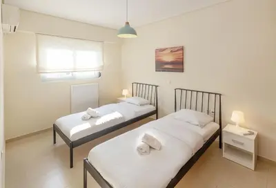 two beds in a room with white sheets at Urban Oasis with Acropolis Views by GHH in Athens