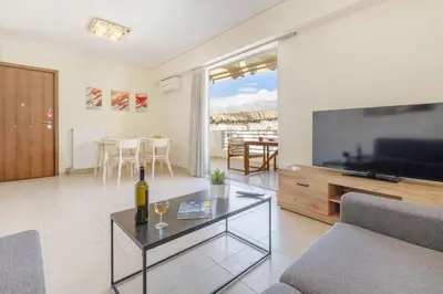 a living room with a television and a bottle of wine at Urban Oasis with Acropolis Views by GHH in Athens