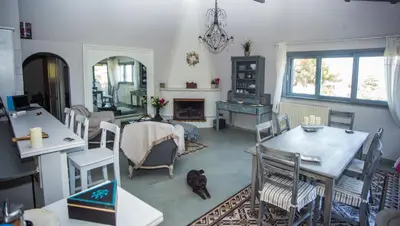 a living room with a table and chairs and a fireplace at Lili and Blue - Charming house in Porto Rafti