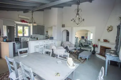 a kitchen and living room with a table and chairs at Lili and Blue - Charming house in Porto Rafti