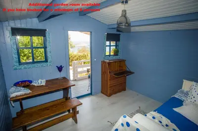 a room with a bed and a desk and a window at Lili and Blue - Charming house in Porto Rafti