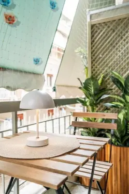 a table with a lamp on top of a balcony at KalaGans CosyHome in Athens
