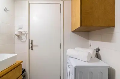 a bathroom with a white sink and a white washing machine at Bee Home - Apartment in Kypseli Central Athens in Athens