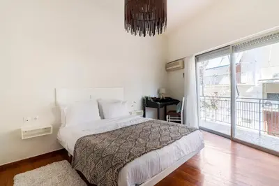 a bedroom with a bed and a large window at Bee Home - Apartment in Kypseli Central Athens in Athens