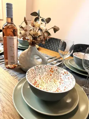 a table with a bowl and plates and a bottle of wine at City Center Acropolis area Maisonette Modern House in Athens