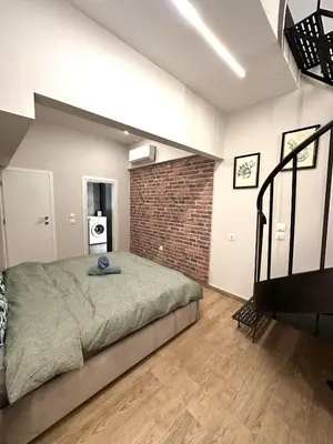 a bedroom with a bed and a brick wall at City Center Acropolis area Maisonette Modern House in Athens