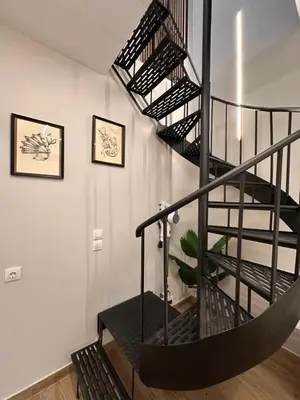a spiral staircase in a house with a plant at City Center Acropolis area Maisonette Modern House in Athens
