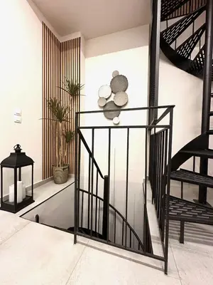 a staircase in a living room with black railings at City Center Acropolis area Maisonette Modern House in Athens