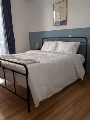 a large bed with white sheets and pillows on it at 2 Bedroom Apartment near Prestigious Kolonaki Square in Athens