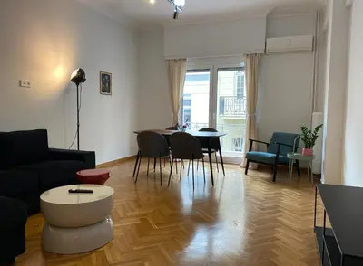 a living room with a couch and a table and chairs at 2 Bedroom Apartment near Prestigious Kolonaki Square in Athens
