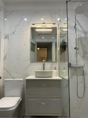 a bathroom with a sink and a toilet and a mirror at 2 Bedroom Apartment near Prestigious Kolonaki Square in Athens