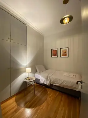 a bedroom with a bed and a table with a lamp at 2 Bedroom Apartment near Prestigious Kolonaki Square in Athens