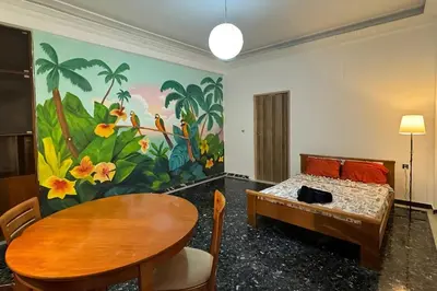 a room with a bed and a table and a mural at Live like a Local in Athens in Piraeus
