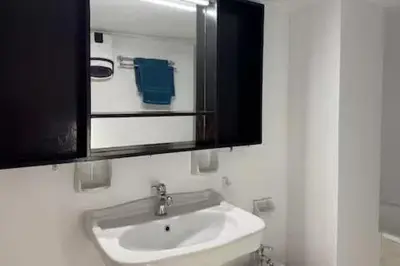 a bathroom with a white sink and a mirror at Live like a Local in Athens in Piraeus