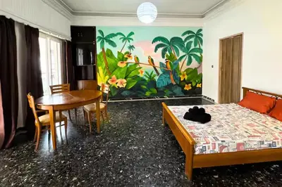 a bedroom with a bed and a table and a dining room at Live like a Local in Athens in Piraeus