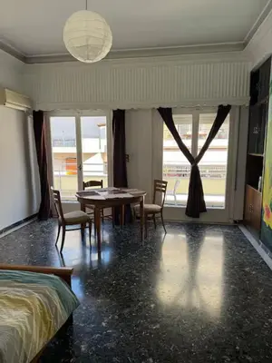 a bedroom with a table and chairs and a bed at Live like a Local in Athens in Piraeus