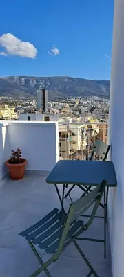 a blue table and a chair on a balcony at Panormou Cityview Loft in Athens