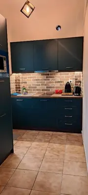 a kitchen with blue cabinets and a tile floor at Urban Nest Apartments in Athens