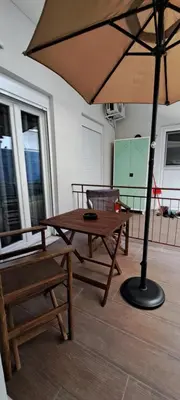 a table and a bench and an umbrella in a room at Urban Nest Apartments in Athens