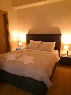 a bedroom with a large bed with two white sheets at Urban Nest Apartments in Athens