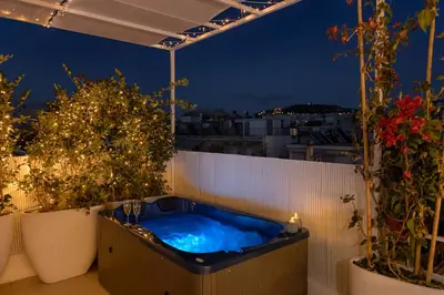 a hot tub on a balcony at night at Aristotelus Studio Jacuzzi & Acropolis View in Athens