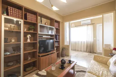 a living room with a couch and a television at In the Heart of the Port Area in Piraeus