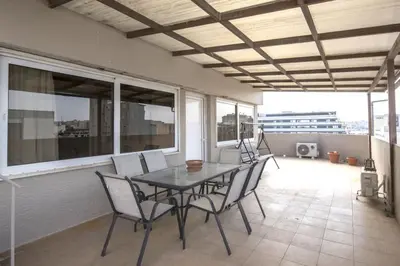 a table and chairs on a balcony with windows at In the Heart of the Port Area in Piraeus