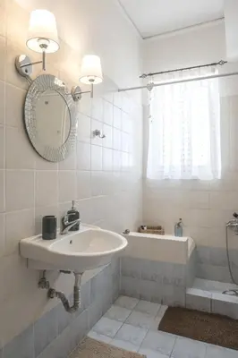 a bathroom with a sink and a tub and a mirror at In the Heart of the Port Area in Piraeus