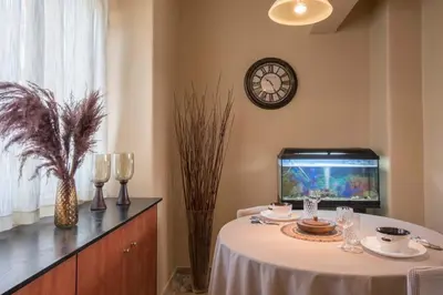 a dining room with a table and a fish tank at In the Heart of the Port Area in Piraeus