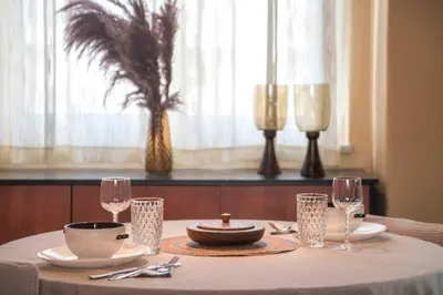 a dining room table with a white table cloth and glasses at In the Heart of the Port Area in Piraeus