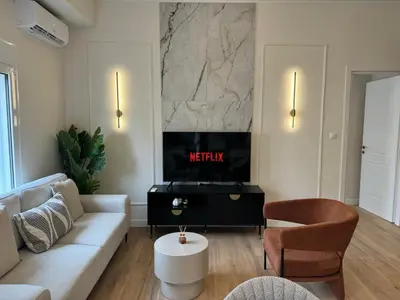 a living room with a couch and a tv at Harbour Getaway in Piraeus