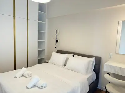 a bedroom with a white bed with two towels on it at Harbour Getaway in Piraeus
