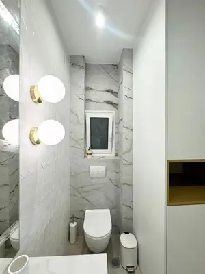 a bathroom with a toilet and a tv on a wall at Harbour Getaway in Piraeus