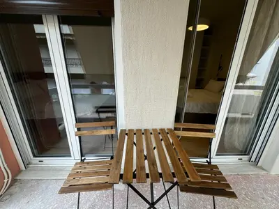 a wooden bench sitting in front of a window at Harbour Getaway in Piraeus