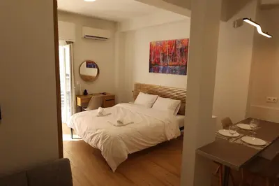a bedroom with a bed and a table and a mirror at Urban Charming Studio for 3 by MPS in Athens