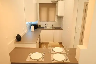 a kitchen with two tables and a cat sitting on a table at Urban Charming Studio for 3 by MPS in Athens